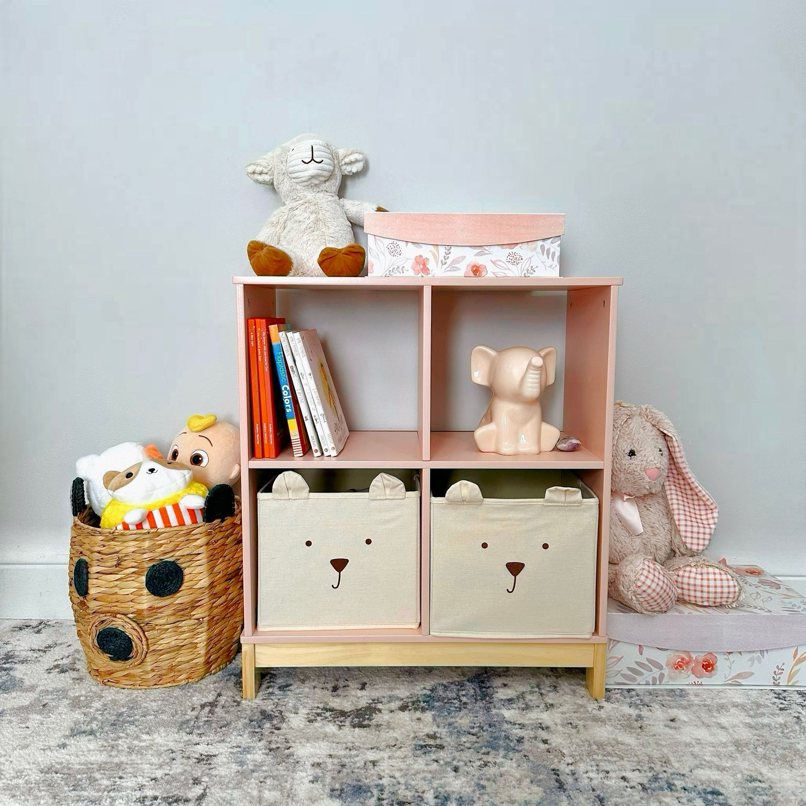 Neatly sorted toys in labelled bins on low shelves beside a tidy, open play area